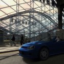 A blue sports car drives past a fairground. | Views: 3319